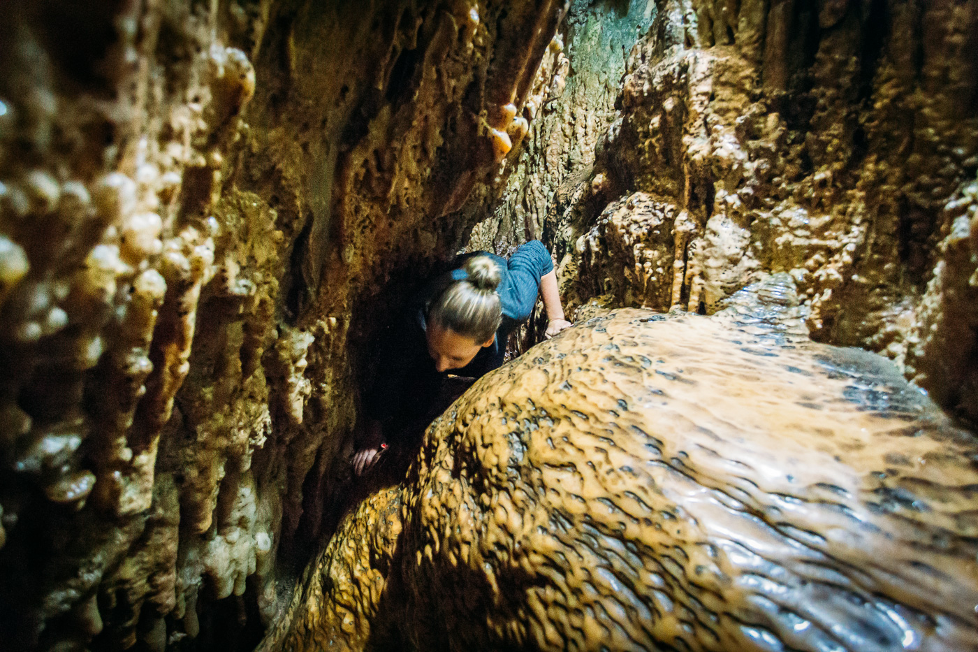 Squeezing through the small crevices of the Cango Caves Adventure Tour